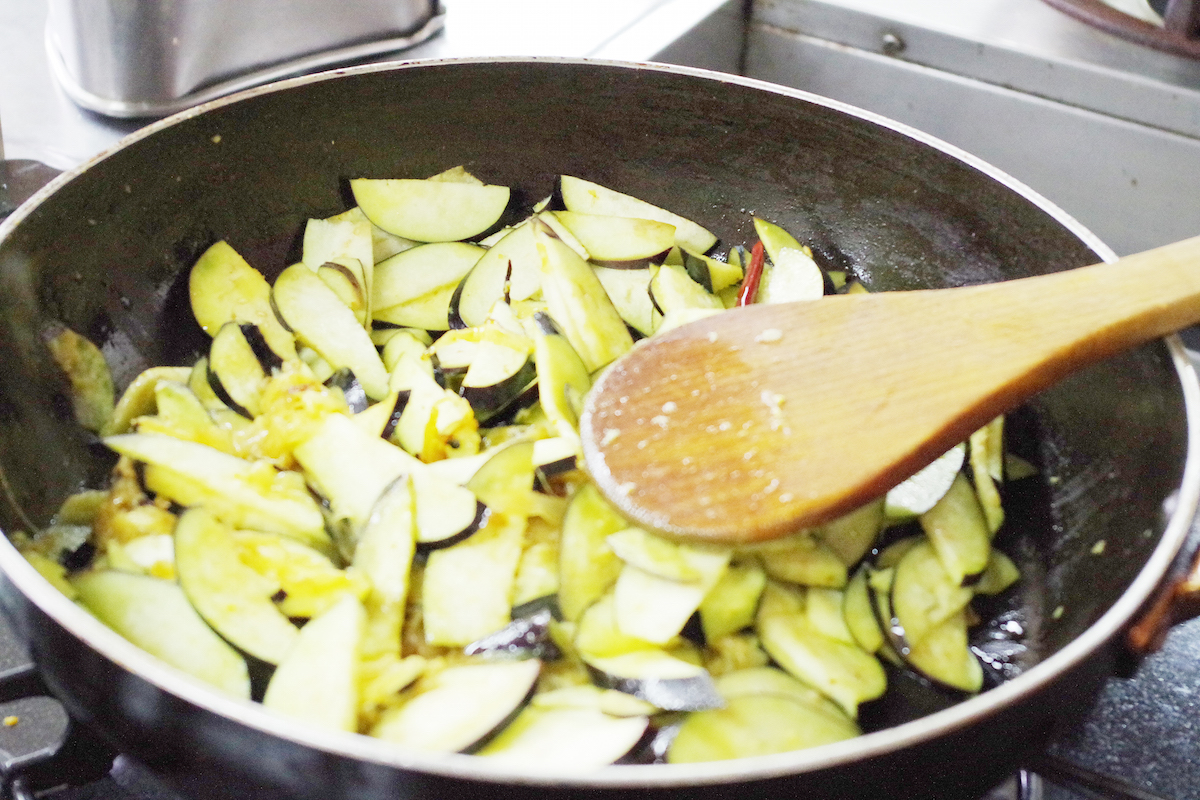 ナスの炒めもの。油を引き、スパイスに火を通してから、ナスを入れます。